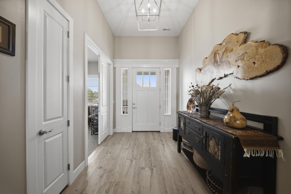 Entryway featuring light wood-style floors and a chandelier