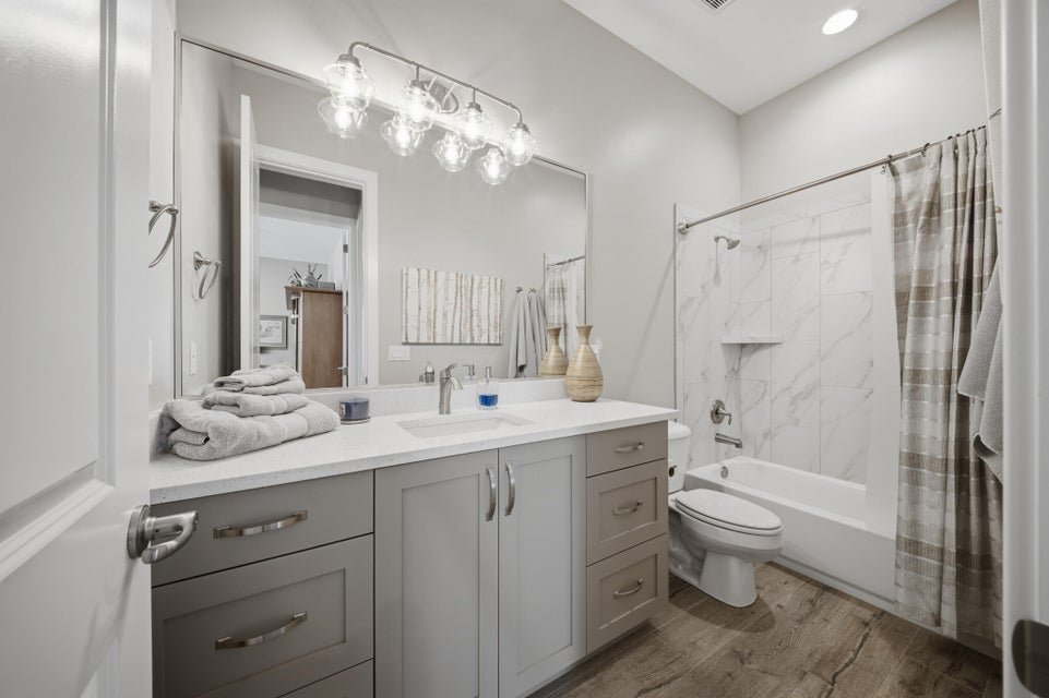 Bathroom featuring vanity, shower / tub combo, light wood finished floors, and recessed lighting