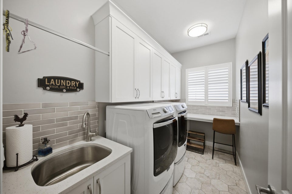 Laundry area with separate washer and dryer, cabinet space, and a wainscoted wall