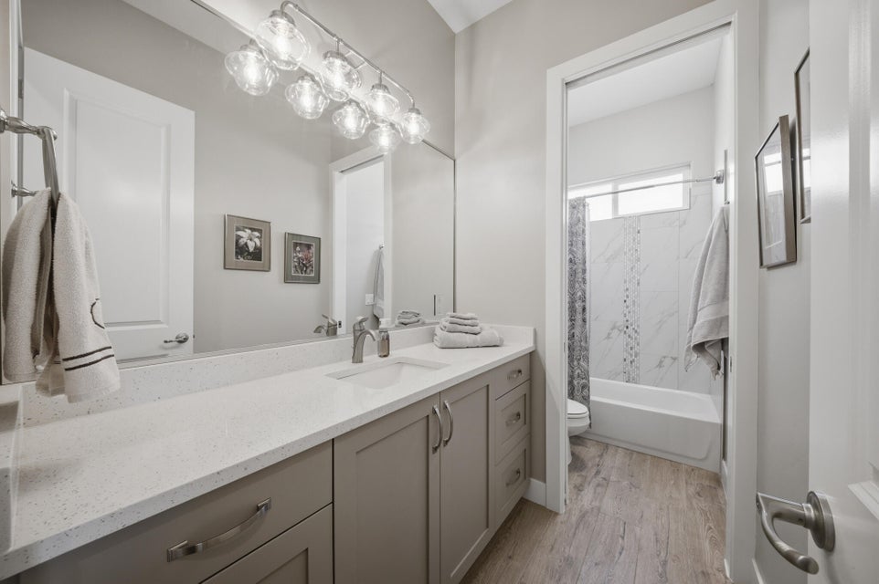 Bathroom featuring vanity,  shower combination, and light wood-style floors
