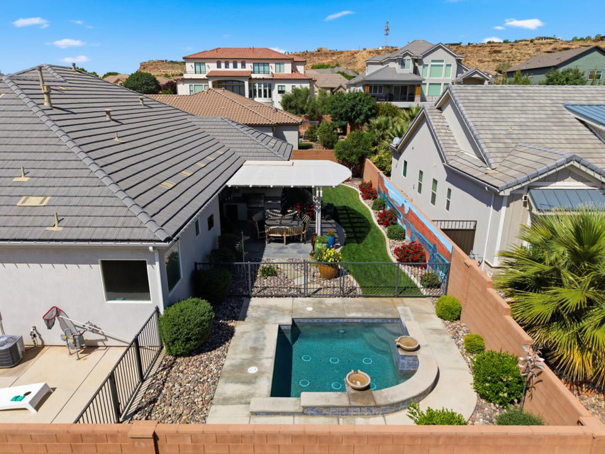 Rear view of property featuring a fenced backyard, a patio area, a tiled roof, and a residential view