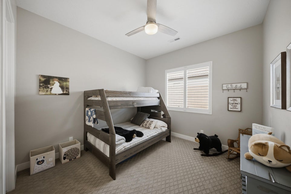 Carpeted bedroom with baseboards and a ceiling fan