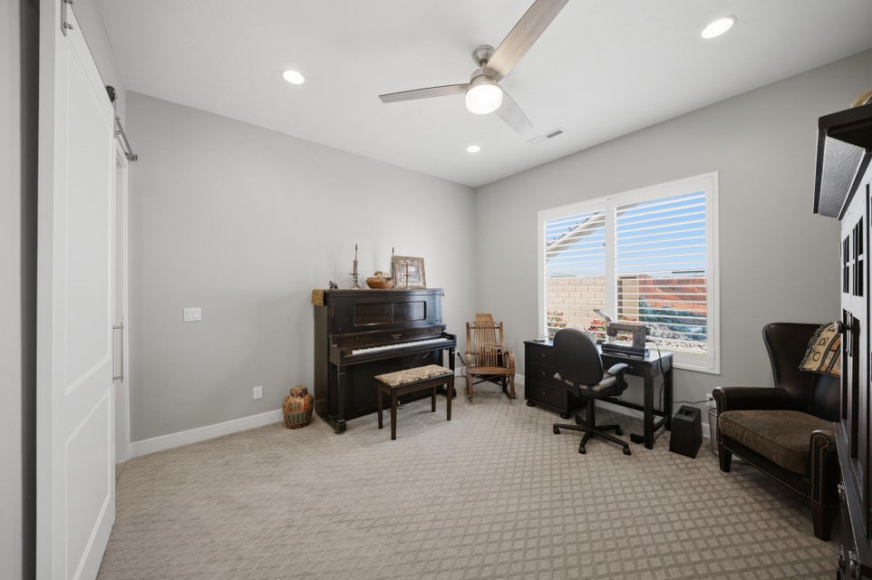 Office space with light carpet, ceiling fan, a barn door, and recessed lighting