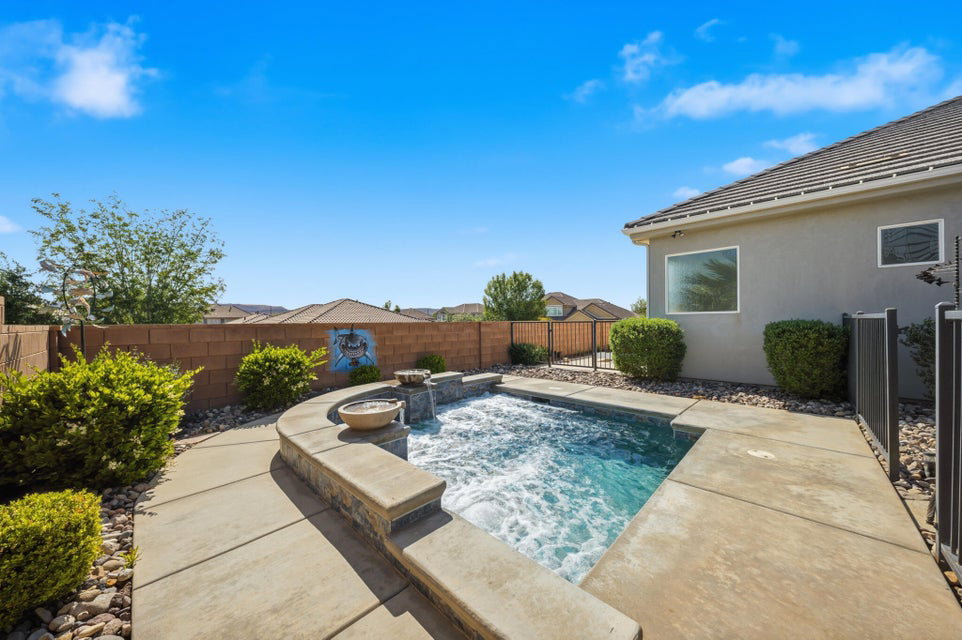 View of pool featuring an in-ground hot tub, a fenced backyard, and patio surround