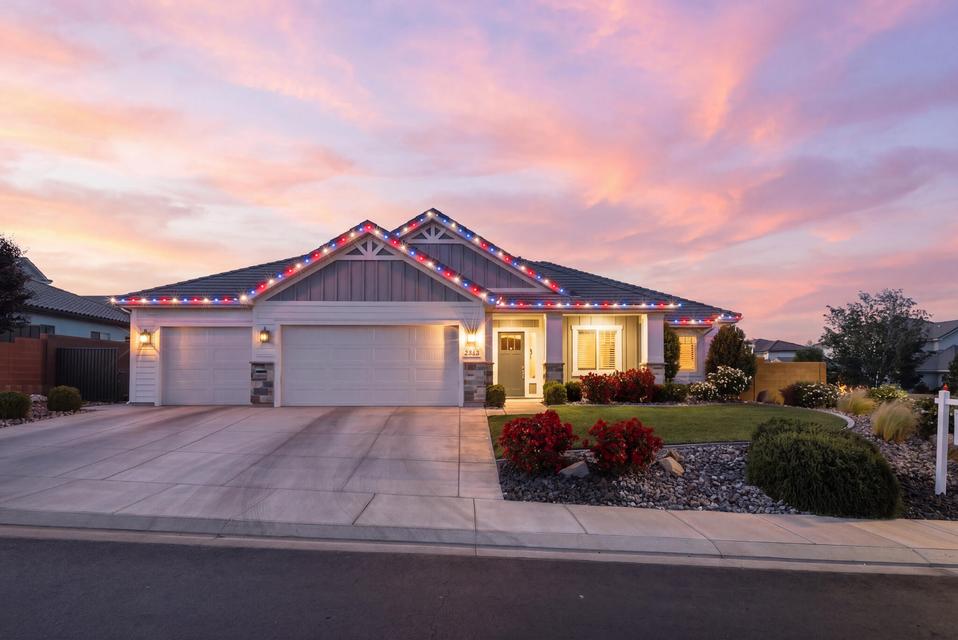 Craftsman-style home with an attached garage, concrete driveway, board and batten siding, and stone siding