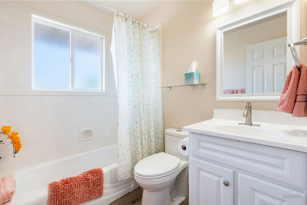 Full bath featuring vanity and shower / bath combo with shower curtain