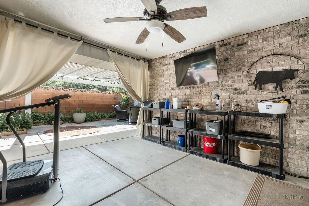 View of patio featuring a ceiling fan and a bar