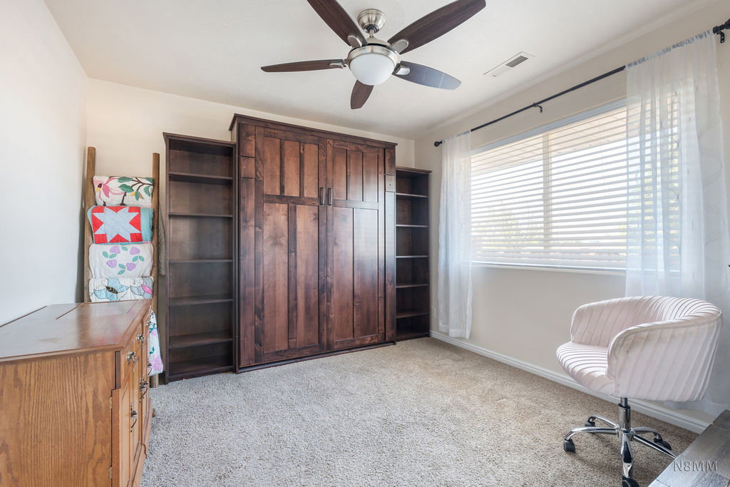 Sitting room featuring light colored carpet and a ceiling fan