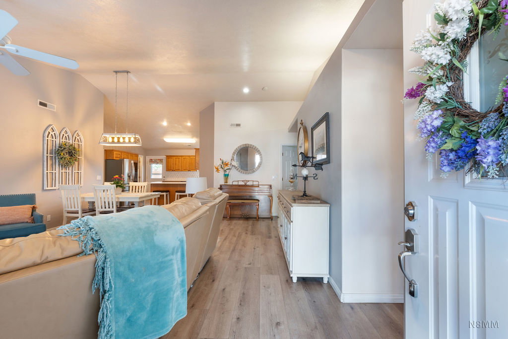 Living area with vaulted ceiling, light wood-style floors, a ceiling fan, and recessed lighting