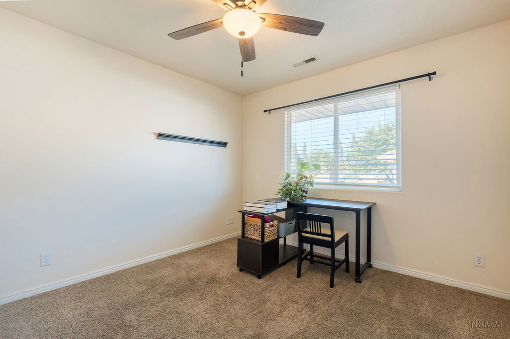 Office space with carpet and a ceiling fan