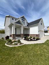 View of front of house featuring brick siding, driveway, a porch, and an attached garage