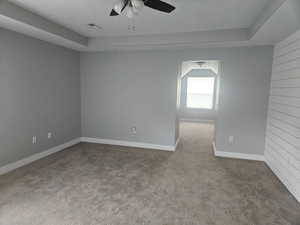 Carpeted spare room with baseboards and ceiling fan