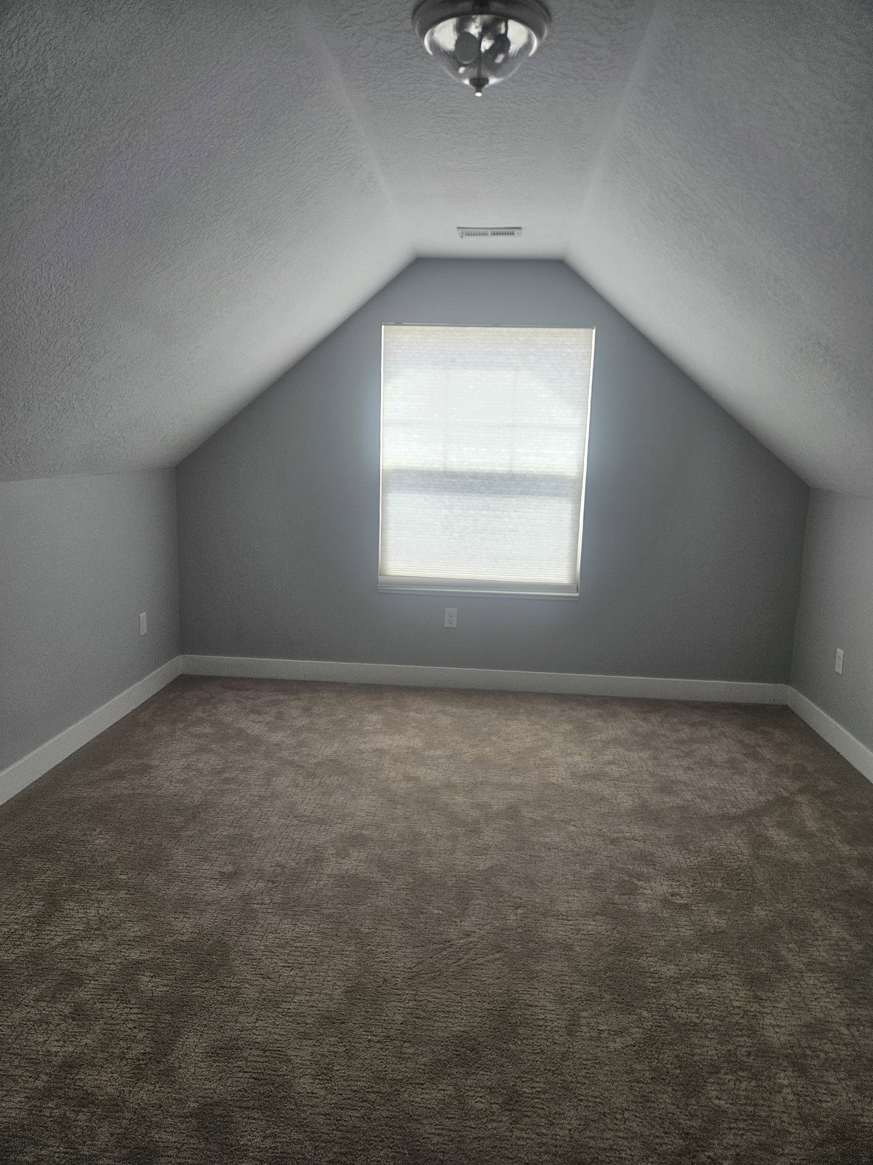 Additional living space with dark carpet and a textured ceiling