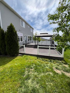 View of grassy yard with a deck and a gazebo