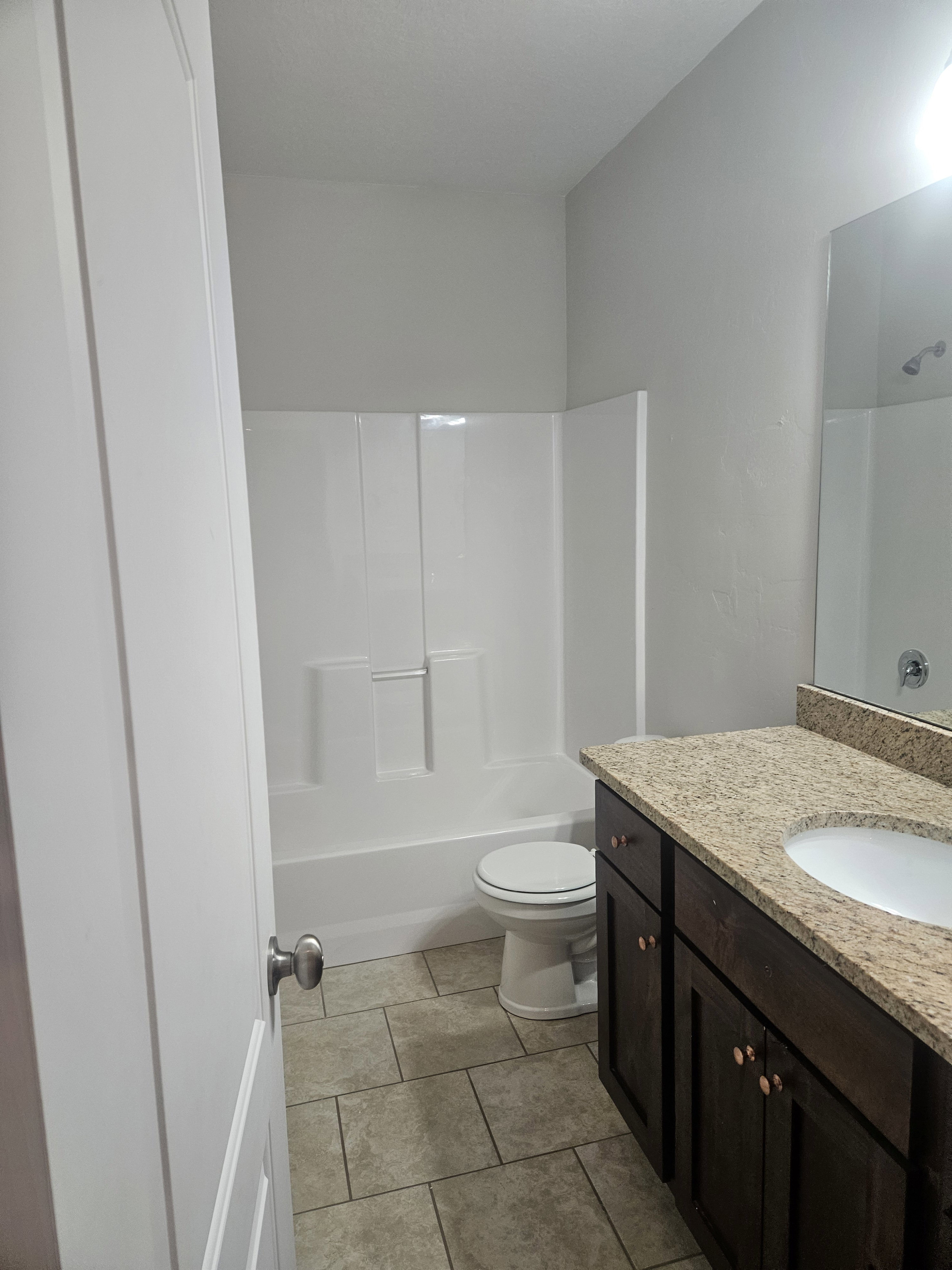 Full bathroom featuring vanity, light tile patterned flooring, and washtub / shower combination