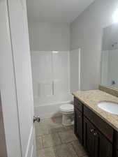 Full bathroom featuring vanity, light tile patterned flooring, and washtub / shower combination