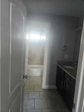 Bathroom with vanity, light tile patterned flooring, and  shower combination