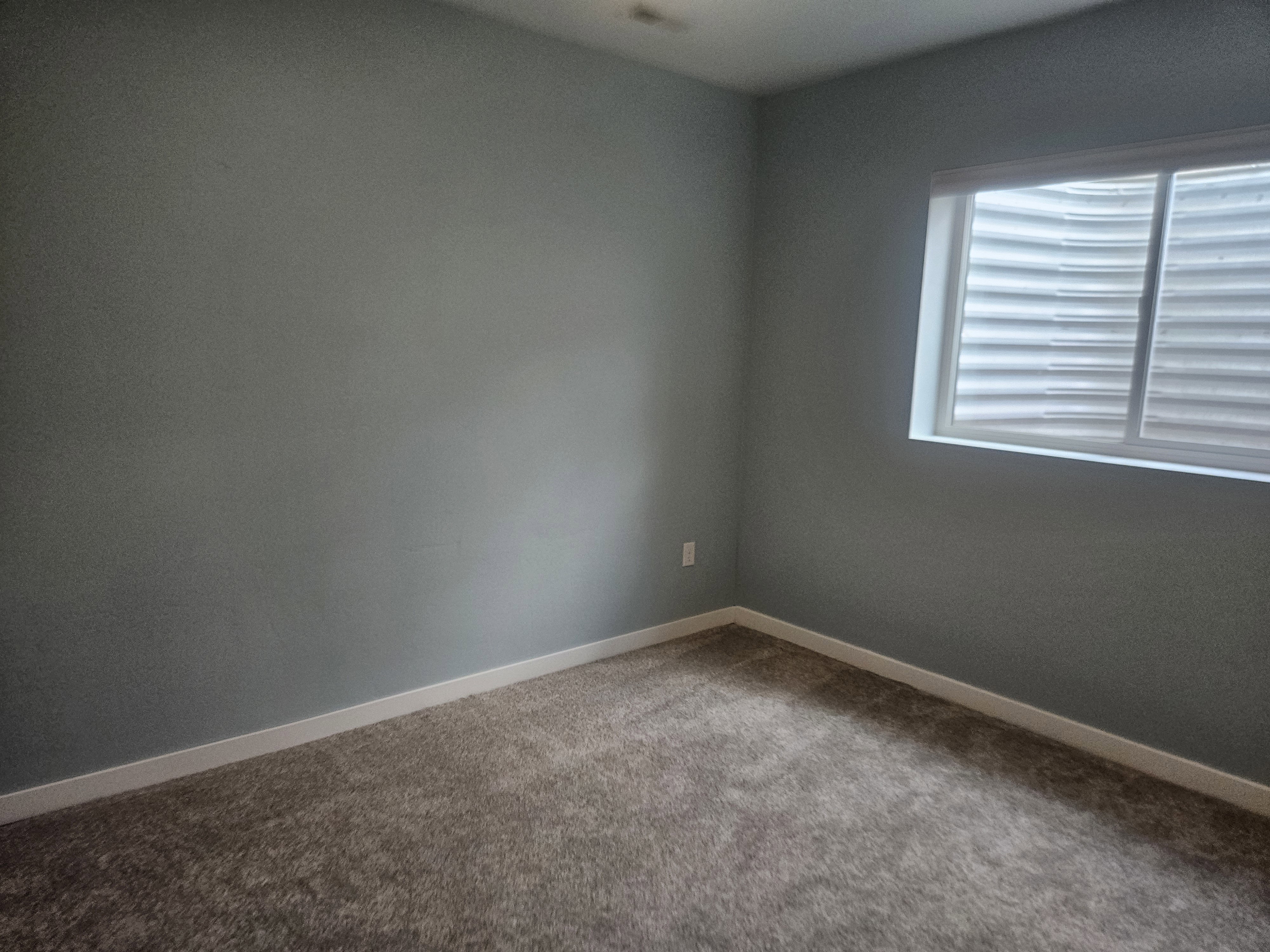 Spare room with light colored carpet and baseboards