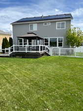 Rear view of property with a gazebo, solar panels, a deck, and stucco siding