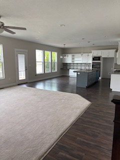Living area featuring dark wood finished floors and a ceiling fan