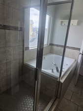 Full bathroom with a garden tub, a stall shower, and tile patterned floors
