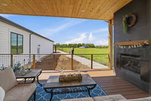 Wooden terrace featuring an outdoor living space with a fireplace