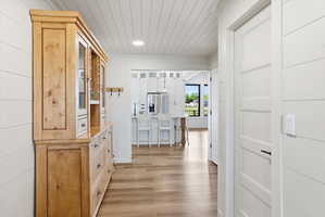 Hall featuring light wood-style flooring, wooden ceiling, and recessed lighting