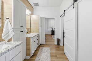 Bathroom with two vanities and light wood-type flooring