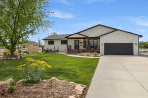 View of front of house with covered porch, a chimney, concrete driveway, a garage, and brick siding