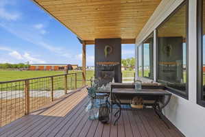 Wooden deck with a lawn and a multi sided fireplace