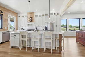 Kitchen featuring white cabinetry, hanging light fixtures, and light wood finished floors