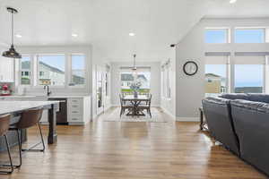 Kitchen with white cabinetry, decorative light fixtures, a breakfast bar, and plenty of natural light