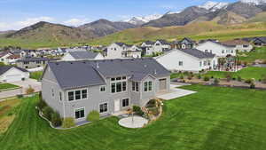 Back of property featuring a patio area, a mountain view, a residential view, and a shingled roof