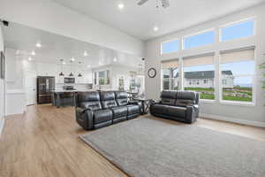 Living room featuring light wood-type flooring, recessed lighting, and a ceiling fan