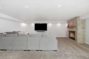Living room with light colored carpet and a stone fireplace