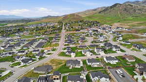 Aerial view of property and surrounding area with nearby suburban area and a mountain backdrop