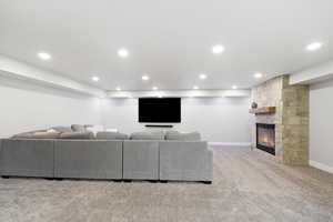 Living room featuring light carpet, a fireplace, and recessed lighting