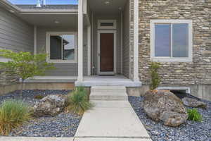 Property entrance featuring stone siding and covered porch