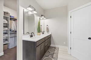 Full bathroom featuring double vanity and a walk in closet