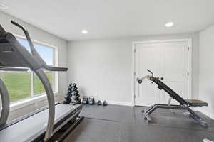Workout area featuring rubber floors and recessed lighting
