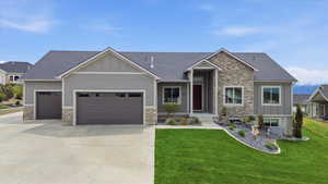 Craftsman house with stone siding, board and batten siding, and an attached garage