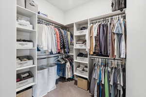 Walk in closet featuring light colored carpet