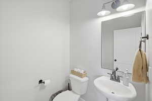Half bath featuring toilet and a sink