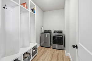 Laundry room featuring light wood-style floors and washing machine and dryer