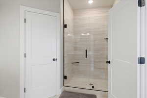 Bathroom with a shower stall and recessed lighting