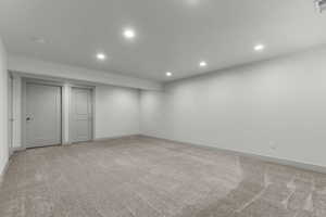 Finished below grade area featuring carpet floors and recessed lighting