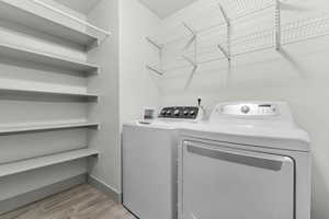 Laundry area featuring washer and dryer and wood finish floors