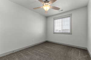 Carpeted spare room featuring baseboards and a ceiling fan