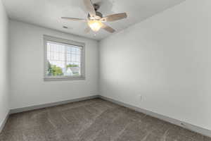Spare room featuring carpet floors and ceiling fan