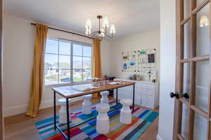 Dining space with light wood-type flooring and hanging lights